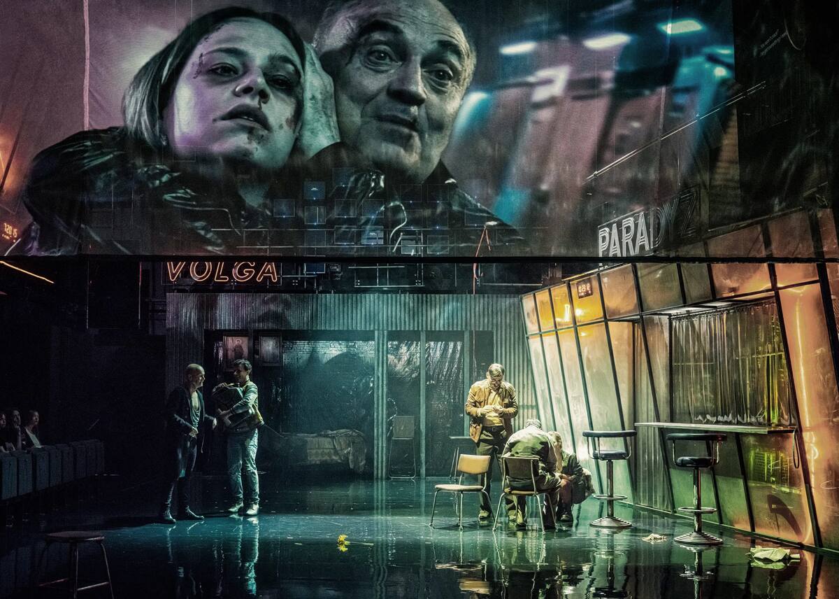 The Minor Apocalypse — actors before enormous projected faces on a multi-room set