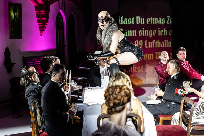 The Damned — a dinner scene under pink light
